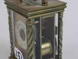 a small brass clock with a key on top of it