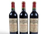 three bottles of red wine sitting next to each other on a white surface