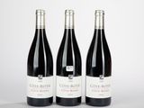 trois bouteilles de vin posées l'une à côté de l'autre sur une table