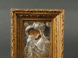 une image représentant un tableau dans un cadre doré, sur lequel figurent une femme et un enfant