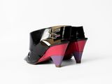 pair of black and pink high heeled shoes on a white surface