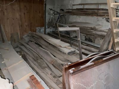 un tas de bois posé dans une pièce, avec une échelle à côté