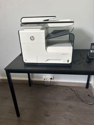 une imprimante posée sur une table, à côté d'un téléphone