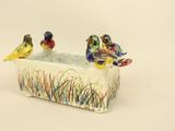 three birds that are sitting in a planter