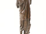 bronze statue of a man holding a bird on a marble base