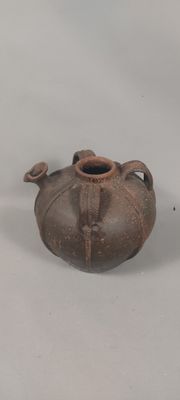 a brown vase sitting on a table with a white background
