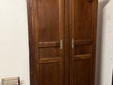 a large wooden armoire in the corner of a room