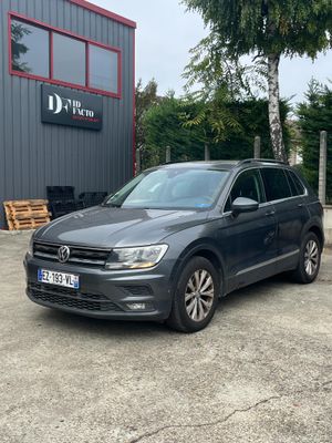 a grey volkswagen tigua parked in front of a building