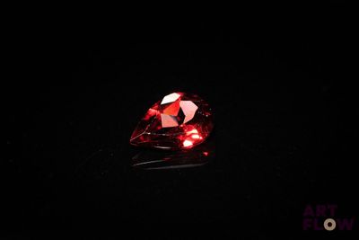 a close up of a red diamond on a black surface