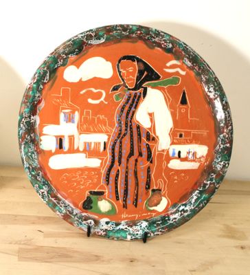une assiette sur laquelle est représentée une femme, posée sur une table
