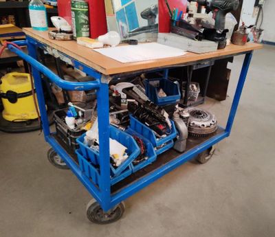 un chariot bleu sur lequel est posé un ordinateur, dans un garage