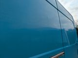 a blue van that is parked on the side of the road