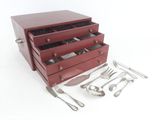 a red box with silverware in it on a white surface