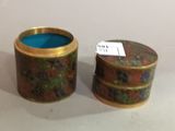 pair of small round tins with a blue lid and a gold rim