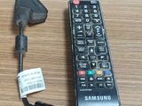 a remote control sitting on a table next to a laptop