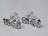 paire de boucles d'oreilles en forme d'arc ornées de diamants, sur fond blanc