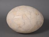 a white stone ball on a gray surface