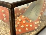 a glass box with a pair of shoes inside of it
