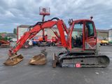a red excavator that is sitting in a parking lot
