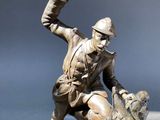 bronze statue of a man on a rock with a bird in his hand