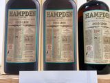 trois bouteilles de Hampden sont posées sur une étagère, avec une étiquette de prix