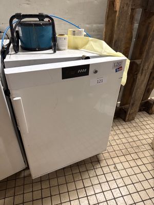 une machine à laver et un sèche-linge blancs posés sur un sol carrelé