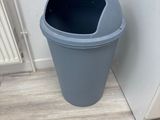 a blue trash can sitting next to a white door