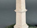 a statue of a man standing on top of a green pedestal