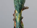 a green and yellow bird sitting on top of a tree branch