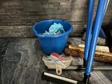 a blue bucket and broom sitting on the floor next to a blue bucket