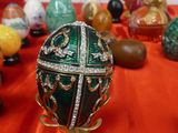 a green and gold faber egg on a red cloth