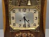 a small wooden clock with a bell on top of it