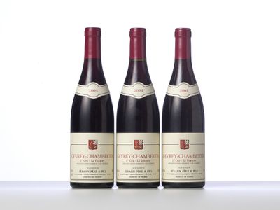 three bottles of red wine sitting on top of a table