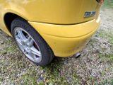 a yellow car that is parked in the grass