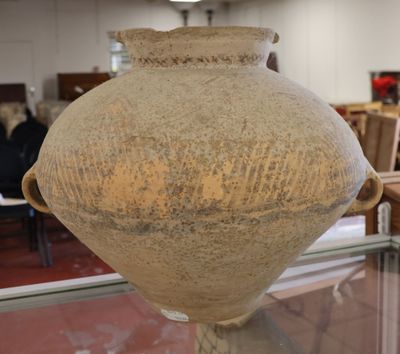 un grand vase posé sur une table en verre dans une pièce