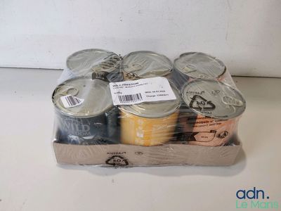 Plusieurs boîtes de conserve se trouvent dans un carton posé sur une table