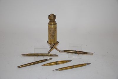 four pens and a pen holder on a table