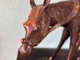 statue of a horse with a saddle on a book on a table