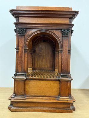 a small wooden clock sitting on top of a wooden table