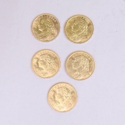 four gold coins are arranged in a row on a white surface