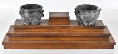 deux vases posés sur un socle en bois, sur fond blanc