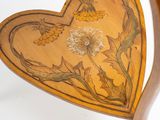 a wooden heart shaped table with a flower design on it