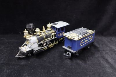 two toy trains that are sitting on a black surface