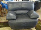un fauteuil inclinable noir posé au milieu d'une pièce