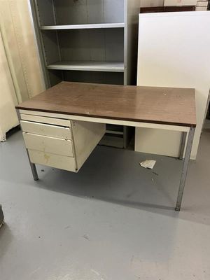 un bureau à deux tiroirs et une armoire dans un coin