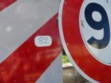 un panneau rouge et blanc sur lequel figure le chiffre neuf