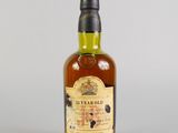gros plan d'une bouteille de whisky sur une surface blanche