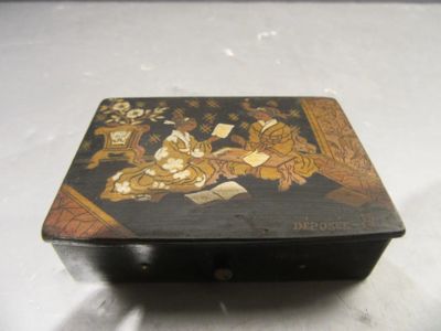 une boîte noire ornée d'une peinture, posée sur une table