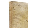 an old book sitting on top of a white table next to a white wall