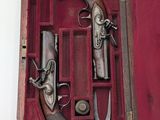 a wooden case with a pair of guns inside of it